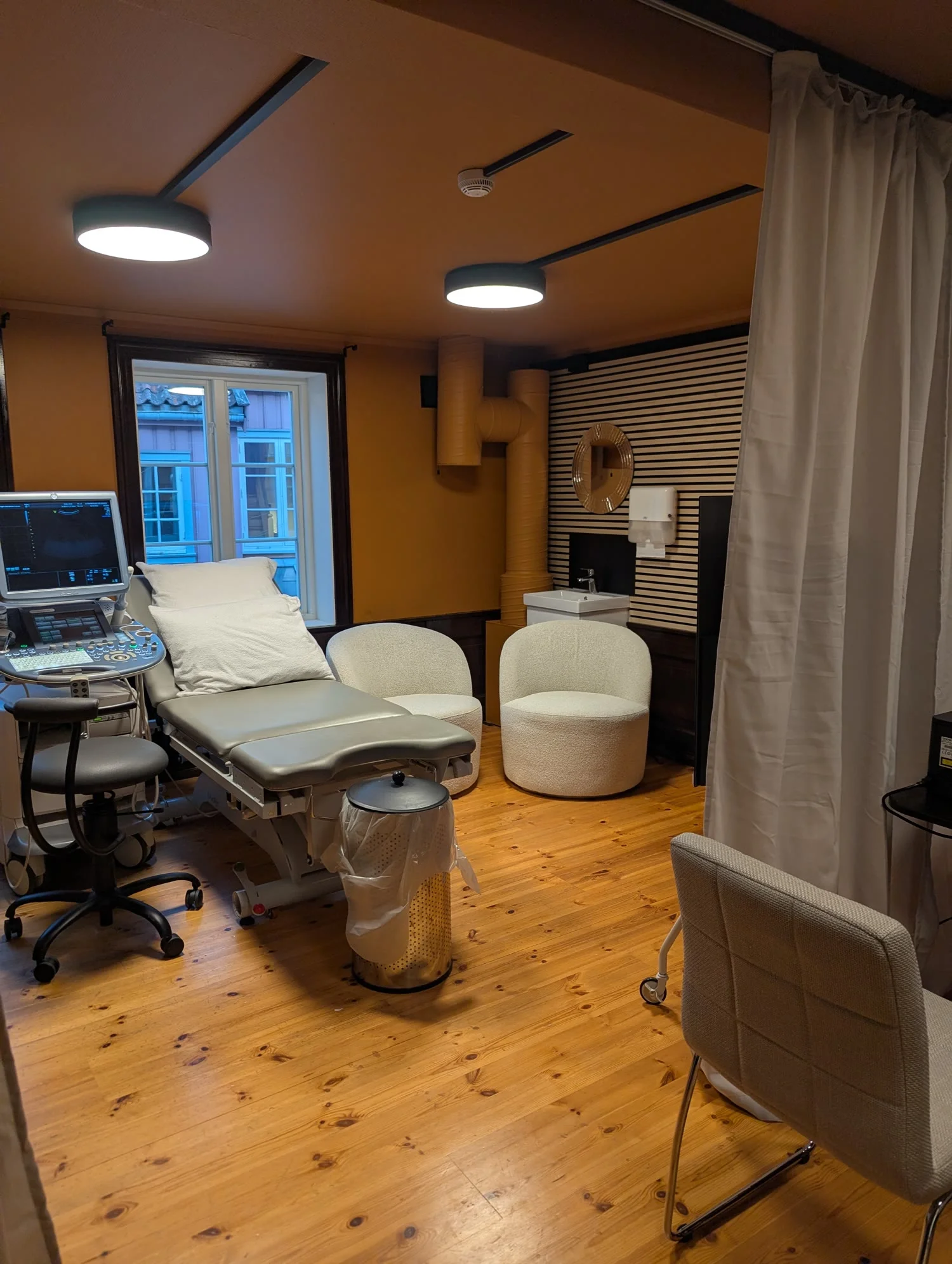 Undersøkelsesrommet med benk, ultralydmaskin og to lenestoler